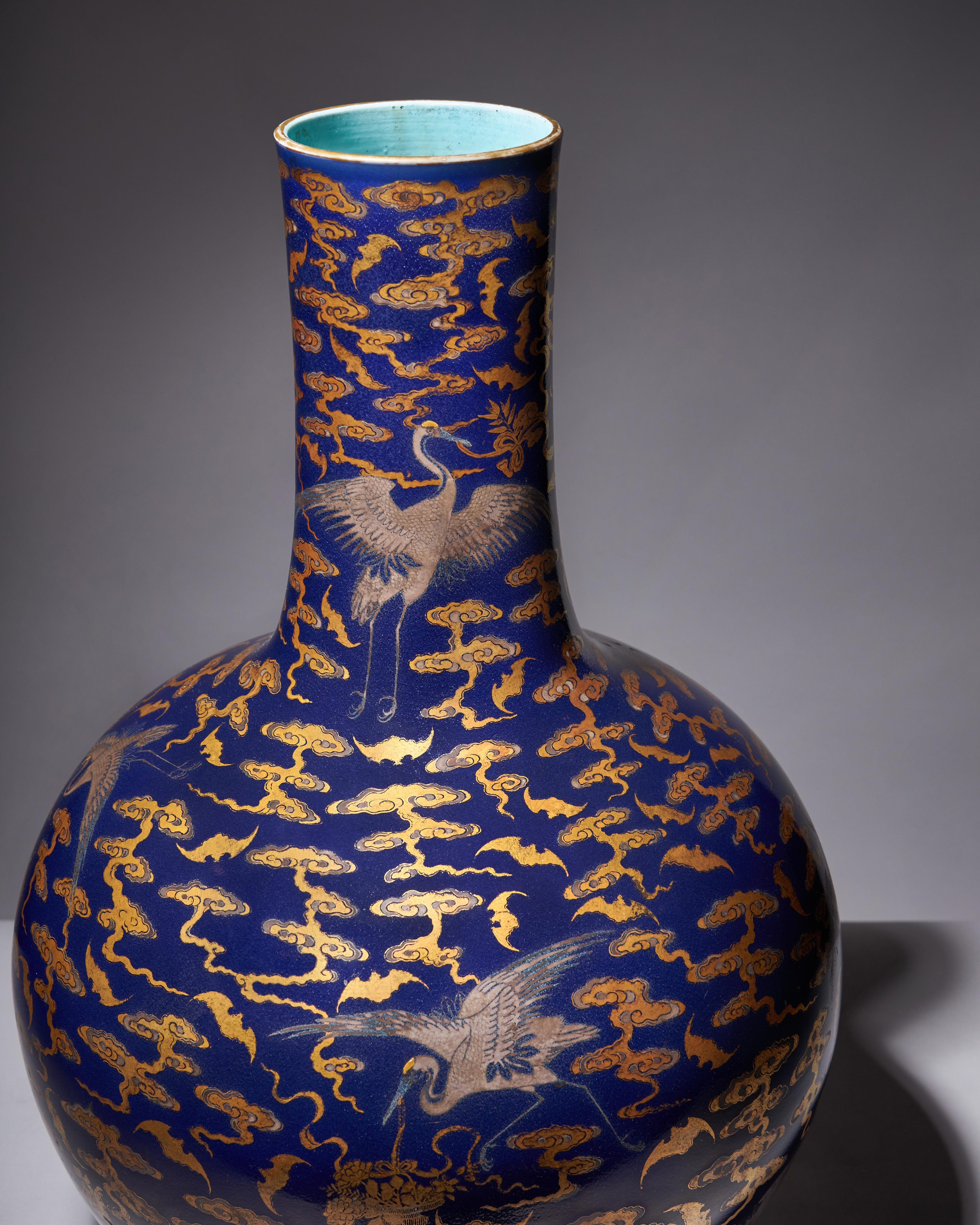 A Qianlong-era blue vase with cranes and bats in silver and gold on it.